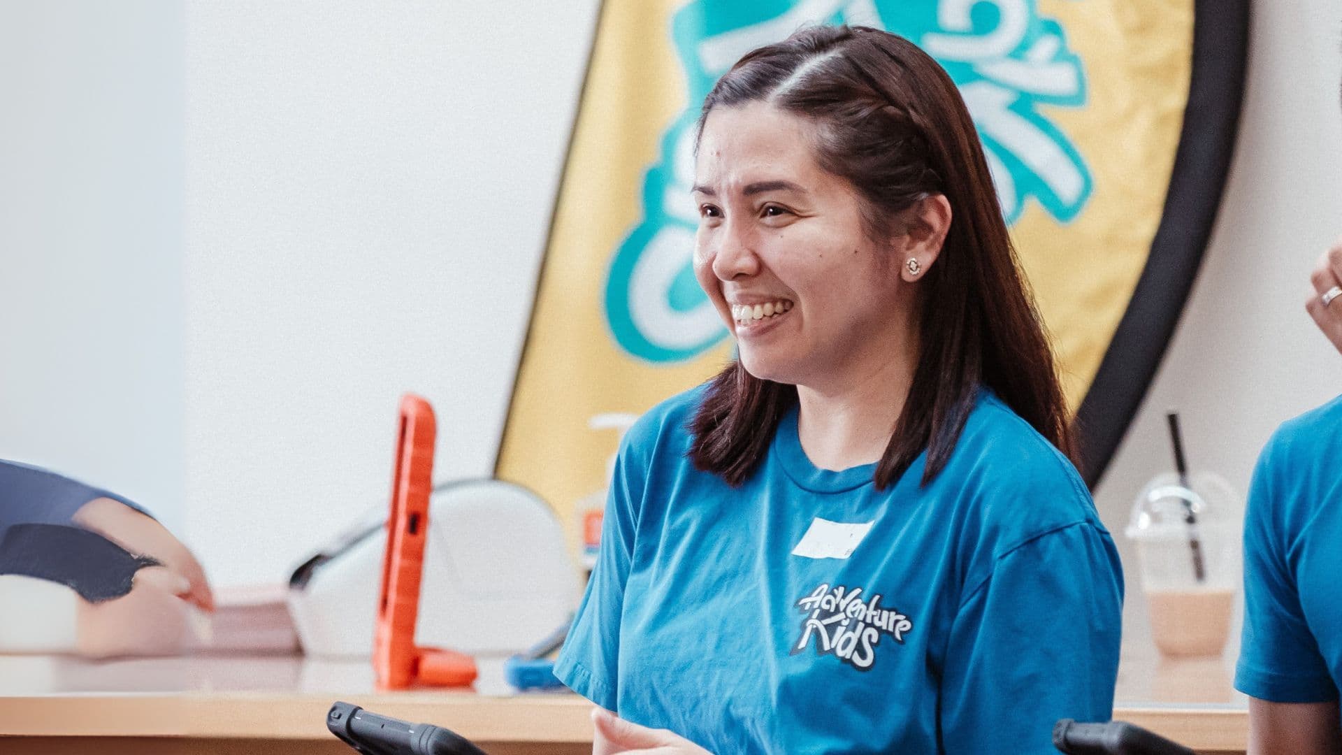 Woman in blue Adventure Kids team t-shirt with iPad for signing kids in