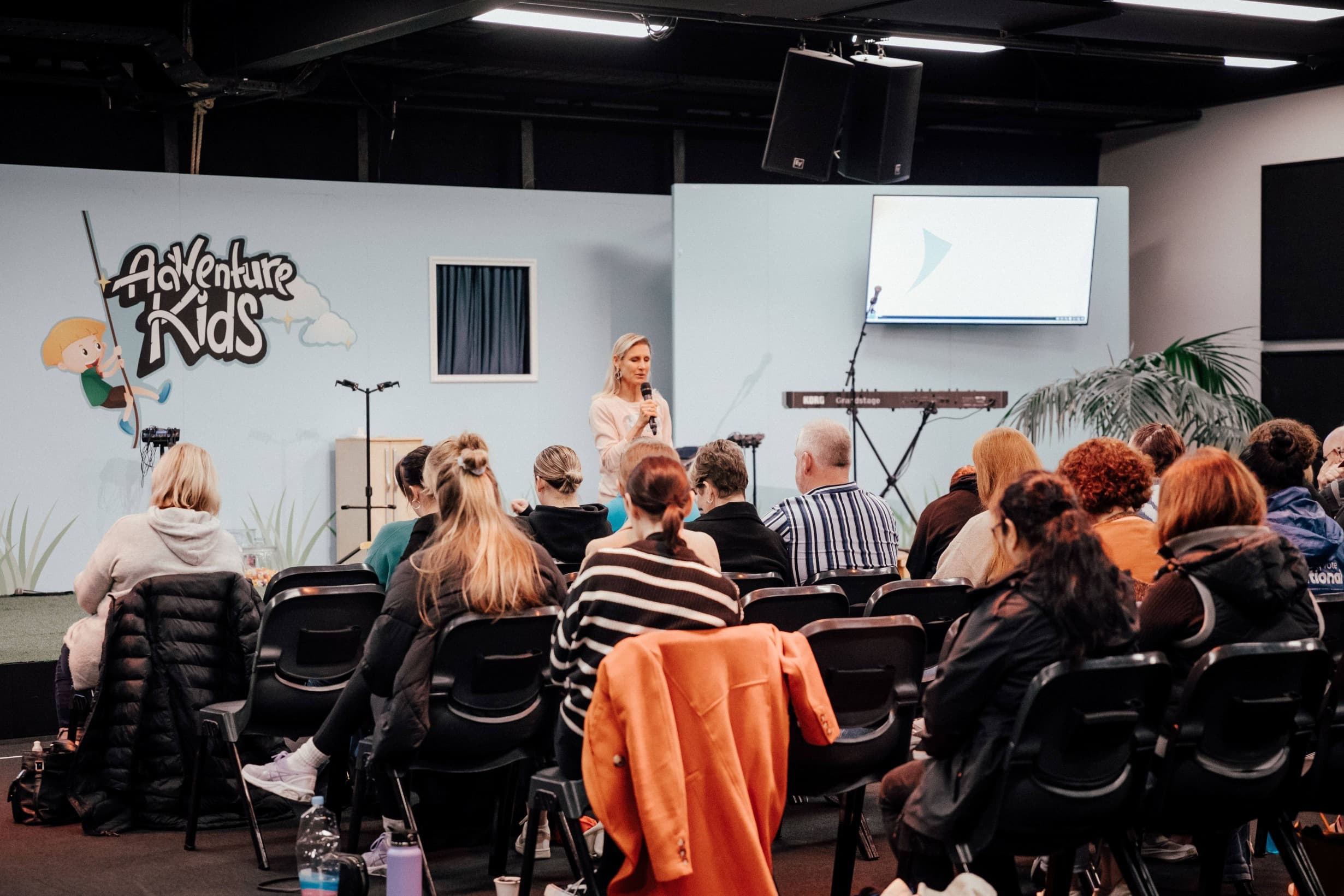 Group of people listening to a presenter speak and pray at the Freedom Course