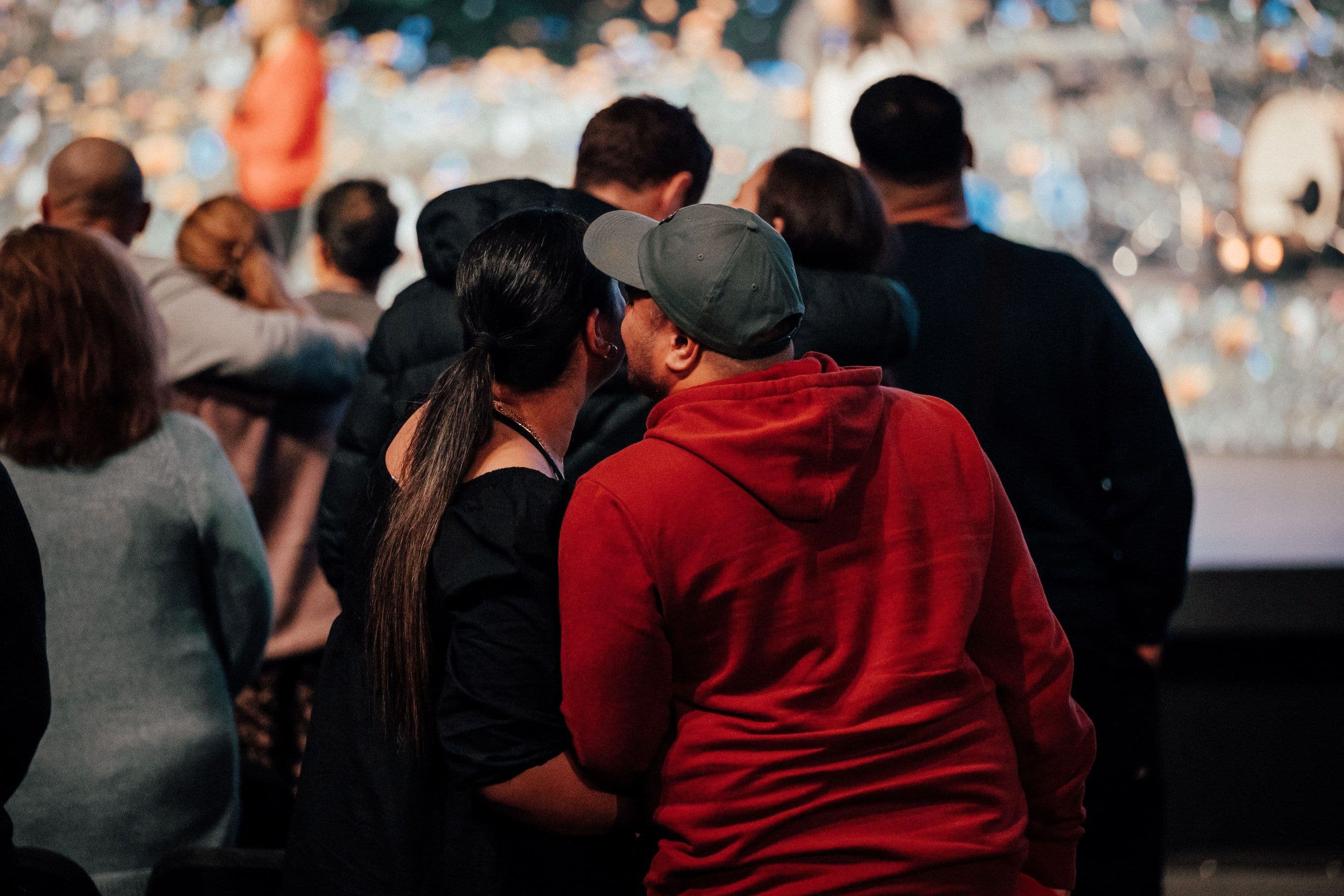 Couple from behind with the man leaning in to whisper in his wife's ear at the Marriage Retreat at LIFE Central