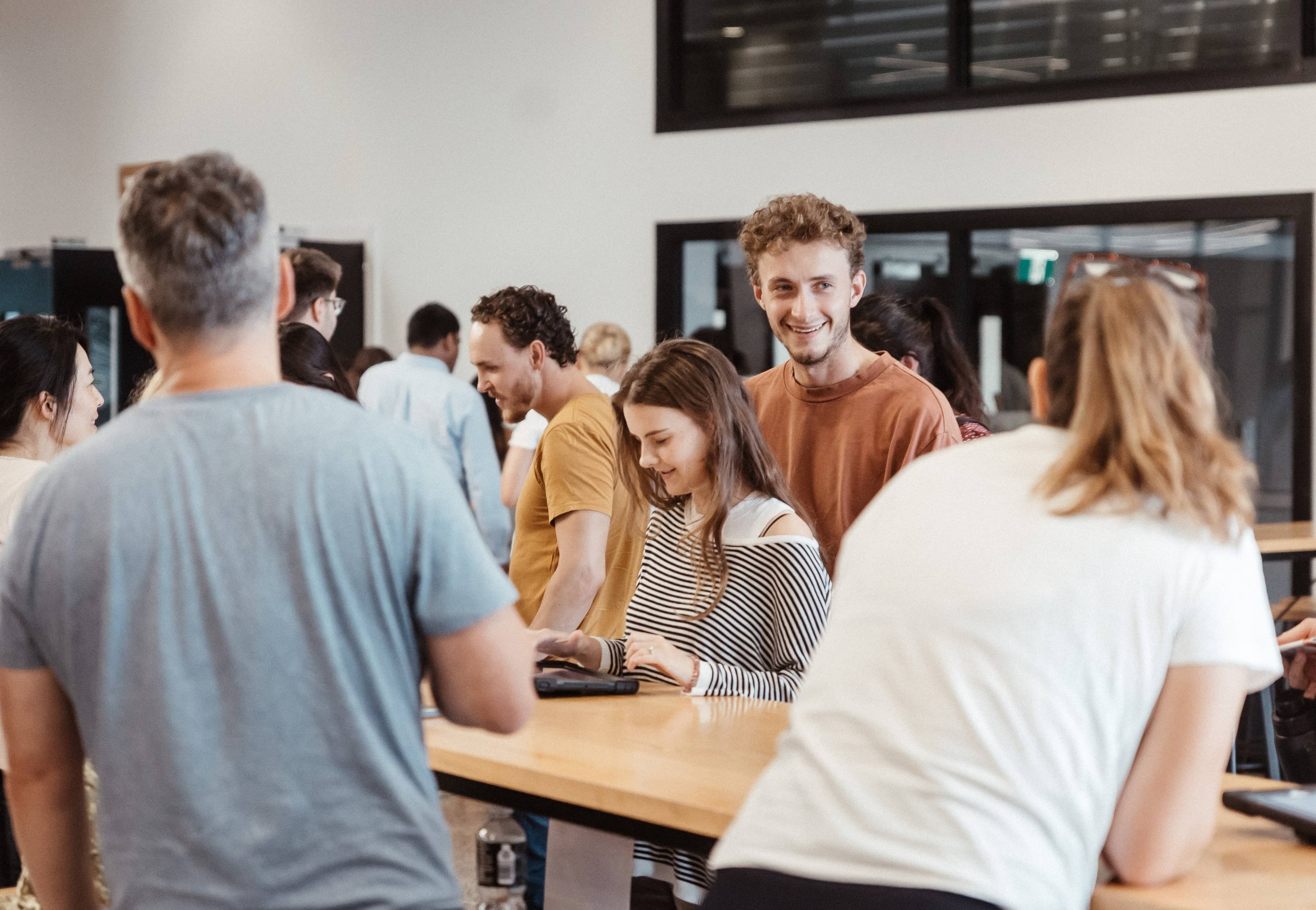 People signing in for Night School course and smiling at each other