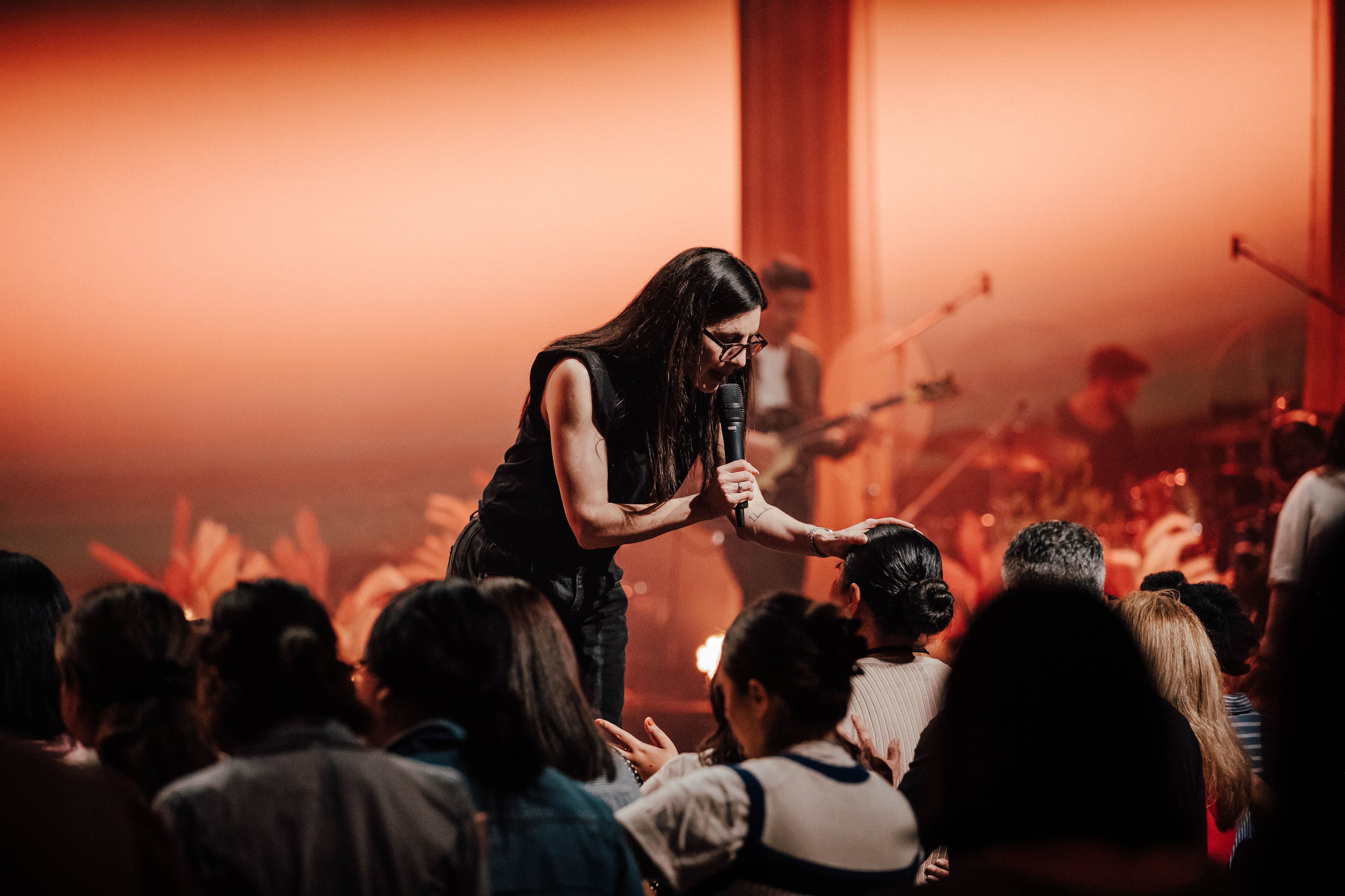 Ps Alex Seeley laying hands on a woman's head and praying over her