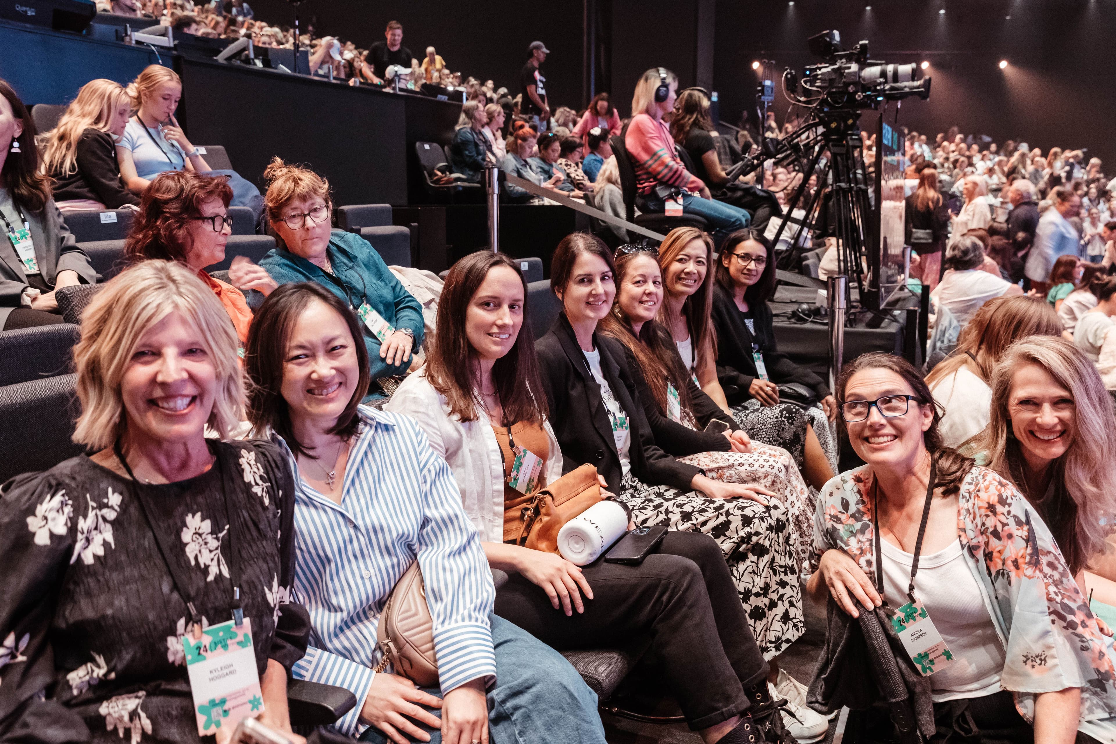 Group of women at Sista's Women's Conference sitting in the Auditorium smiling at the camera
